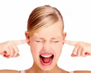 Portrait of disturbed young female screaming while putting finger in her hears