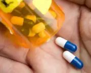 closeup of medicine capsules being poured from pill bottle into hand
